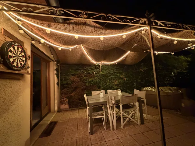 Terrasse couverte éclairée par une guirlande lumineuse