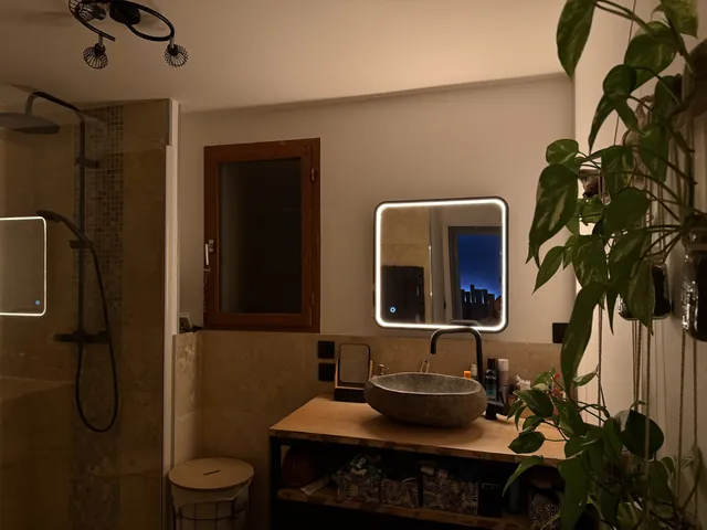 Salle de bains avec miroir lumineux en éclairage chaud