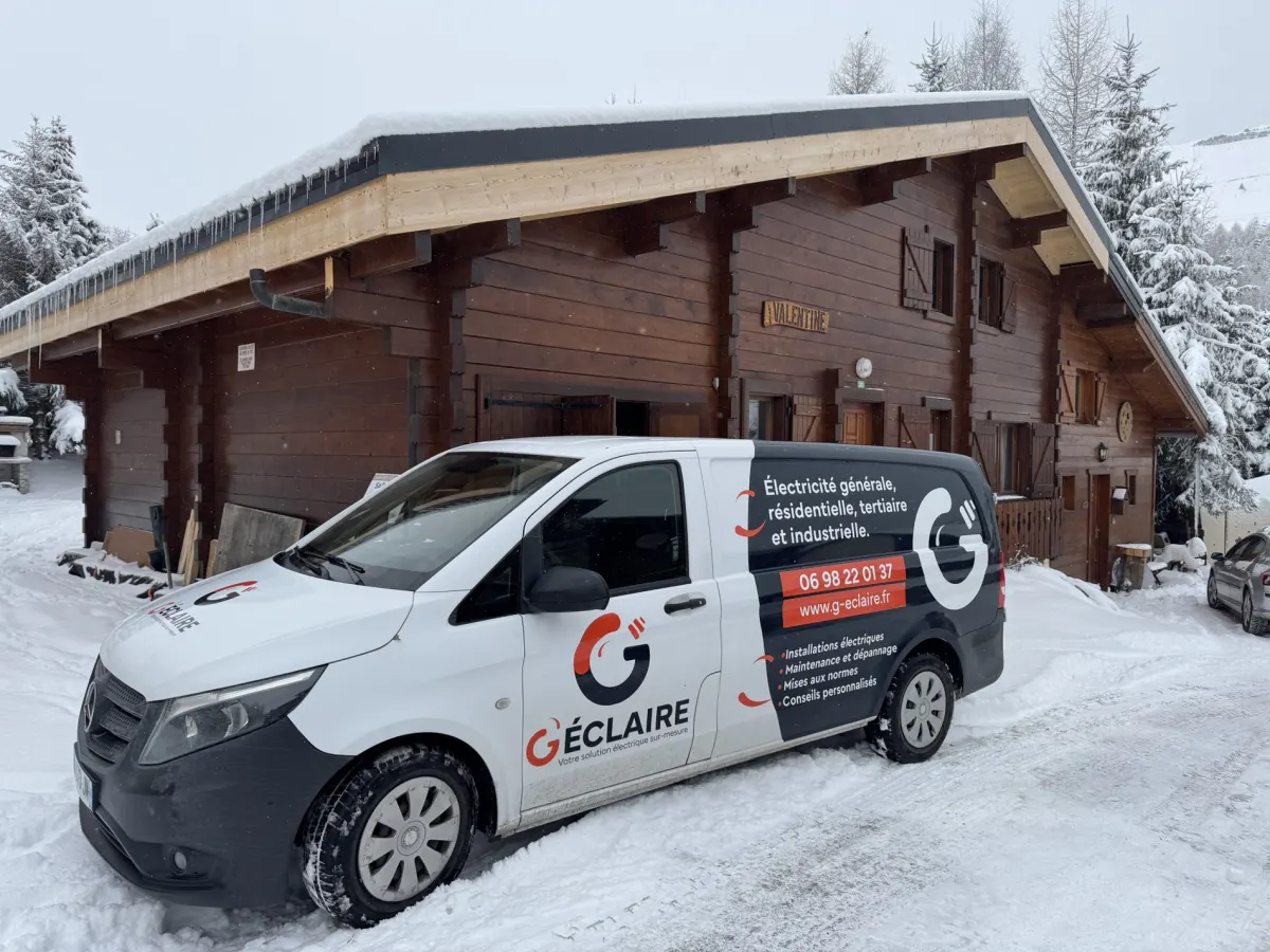 Le camion G'Éclaire devant un chalet enneigé