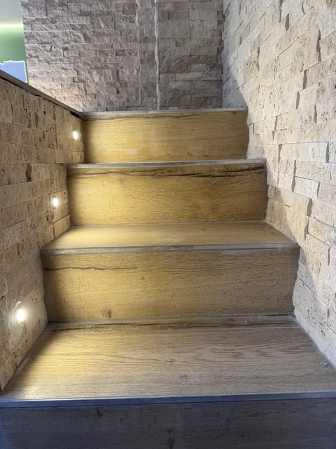 Escalier éclairé par des spots encastrés dans le mur